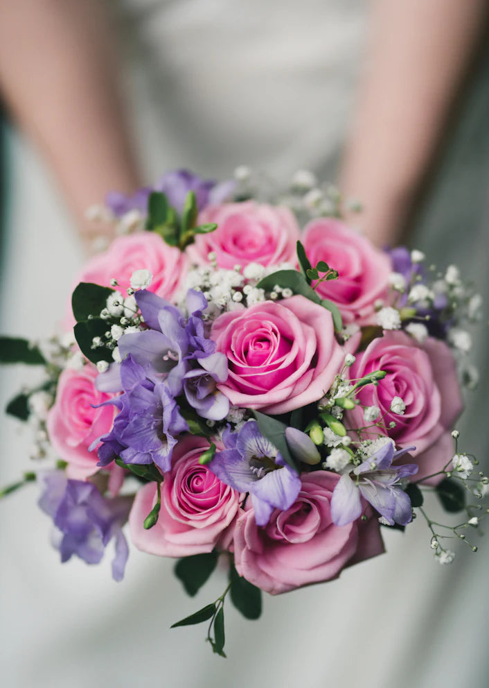Bouquet rosa e lilla tra le mani di una fiorista